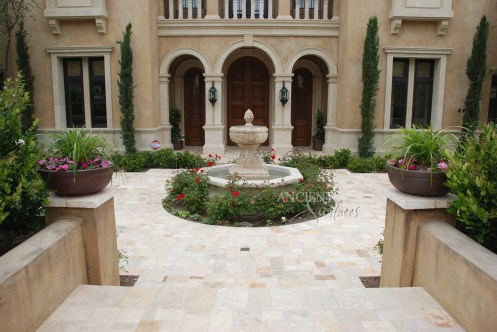 A hand carved entryway courtyard stone fountain sitting on top of reclaimed Arcane Stone flooring. By Ancient Surfaces