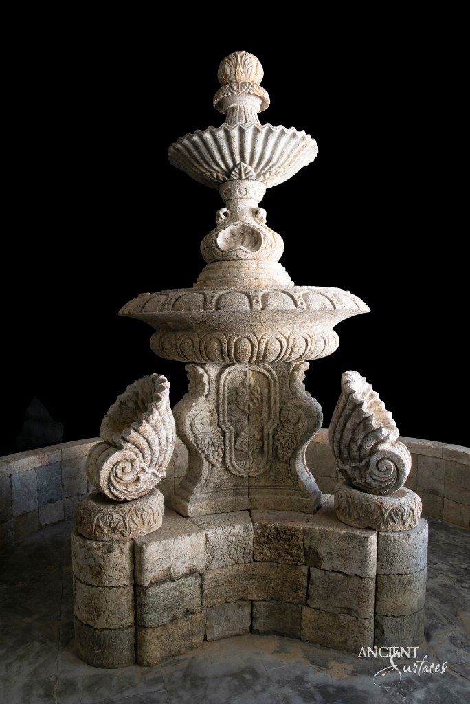 Ancient Greek-style limestone fountain by Ancient Surfaces, adorned with intricate shell motifs and other detailed carvings