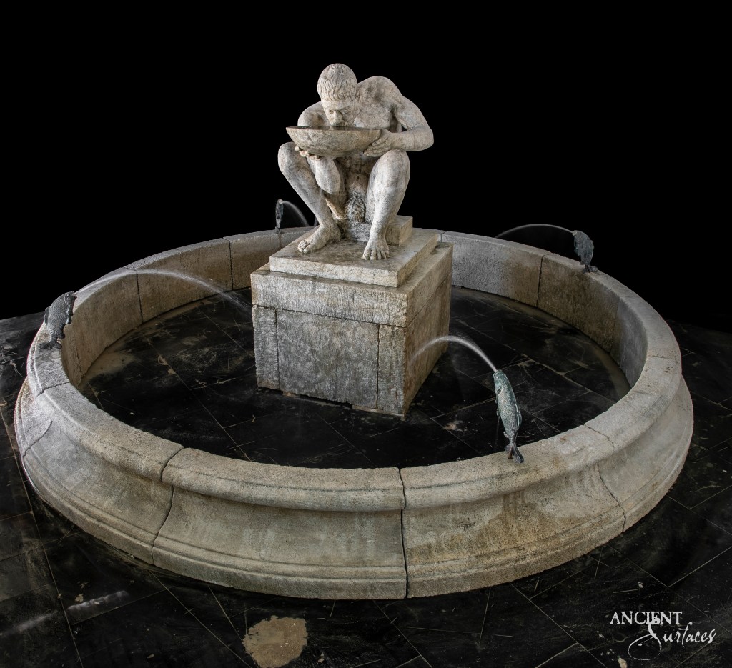 Limestone fountain by Ancient Surfaces, depicting a man drinking from a platter, a unique piece that captures the essence of classical Roman artistry.